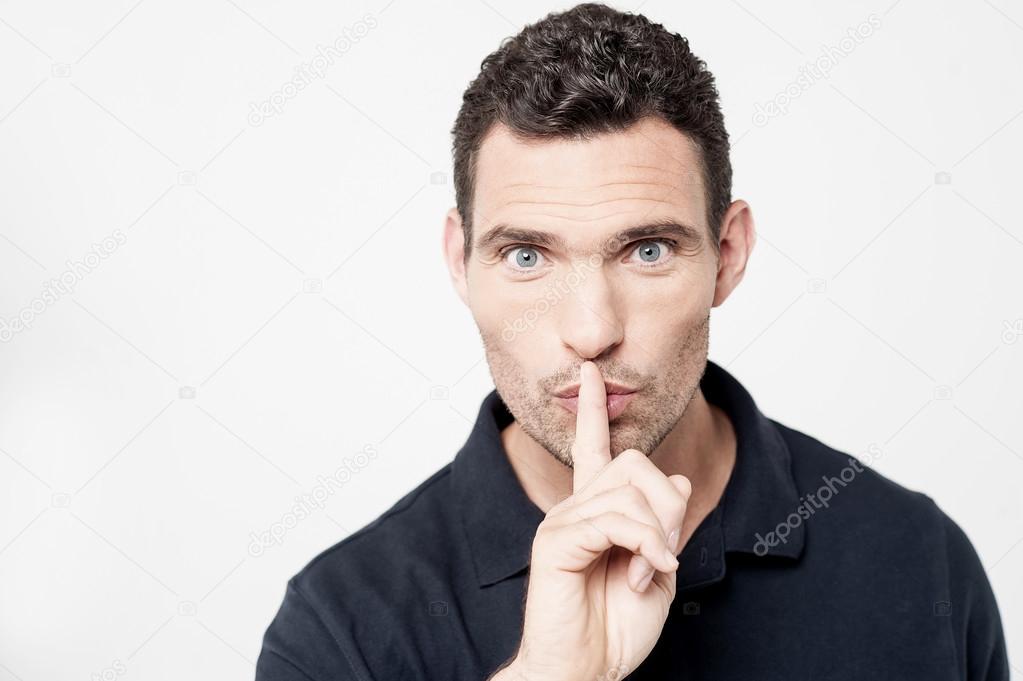 man keeping finger on her lips