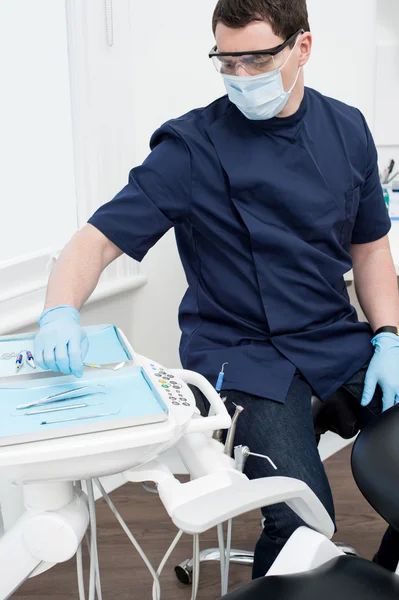 Odontólogo masculino con herramientas en consultorio dental — Foto de Stock