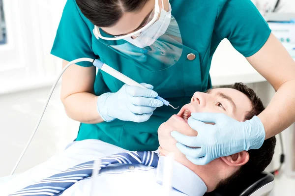 Professional dentist doing teeth checkup — Stok fotoğraf