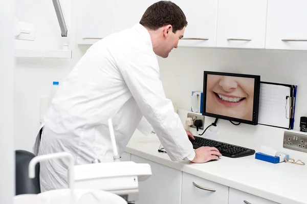 Dentista usando computador na clínica odontológica — Fotografia de Stock
