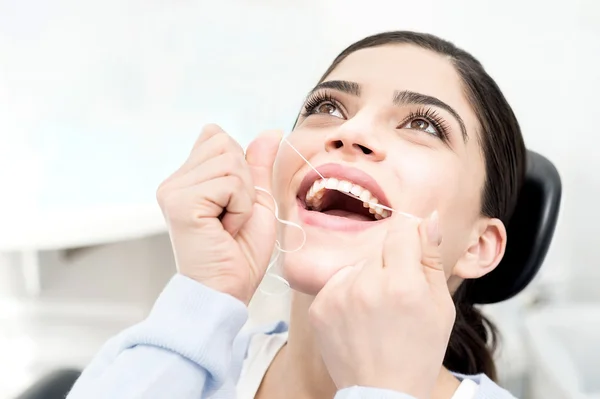 Mulher usando fio dental para limpar os dentes — Fotografia de Stock