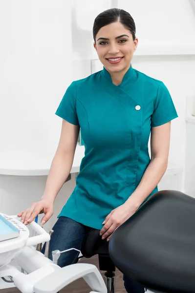 Female assistant seated in dental office — Stok fotoğraf