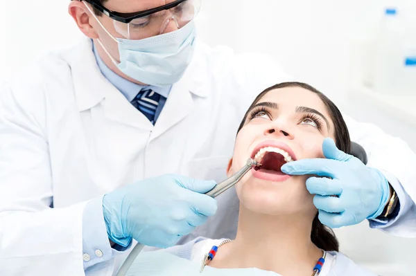 Male dentist treat a woman patient — Stockfoto