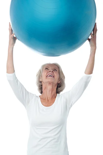 Senior woman holding up the exercise ball — 图库照片