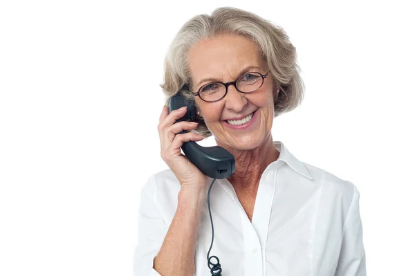 Aged happy woman answering a phone call — Stockfoto