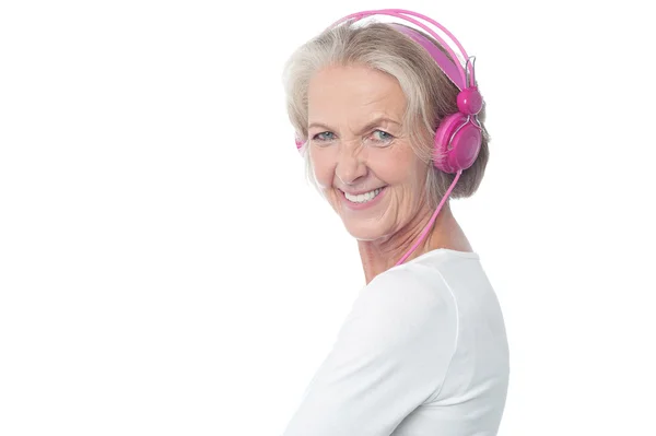 Aged woman listening music — Stok fotoğraf