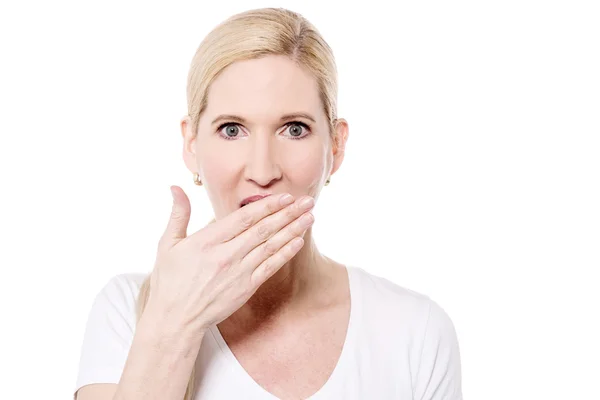 Woman with hand over mouth Stock Picture