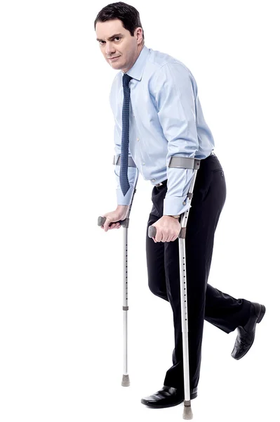 Businessman trying to walk with crutches — Stock Photo, Image