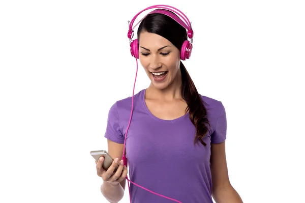 Kvinnan lyssnar musik på sin mobiltelefon — Stockfoto