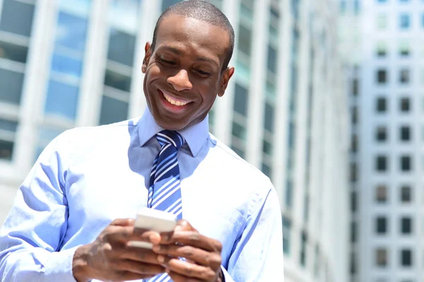 Empresario enviando un mensaje en su teléfono celular —  Fotos de Stock