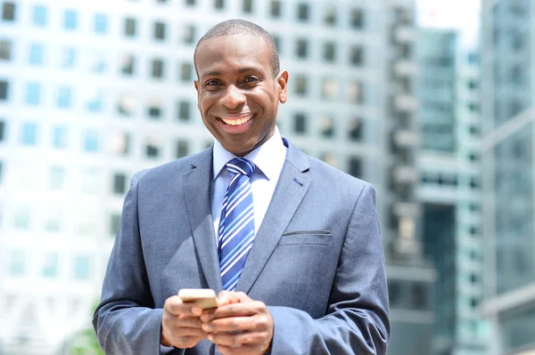 Affärsman poserar med sin mobiltelefon — Stockfoto