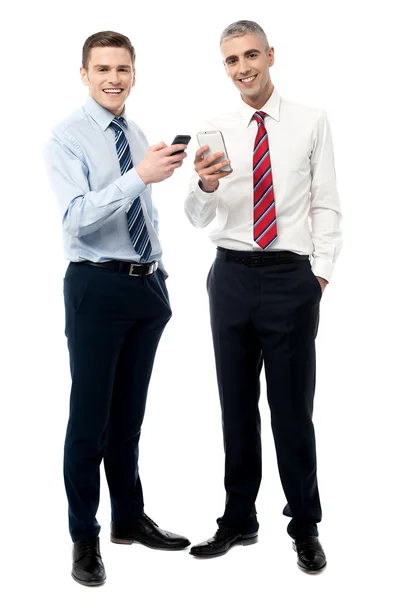 Mannelijke leidinggevenden poseren met mobiele telefoons — Stockfoto