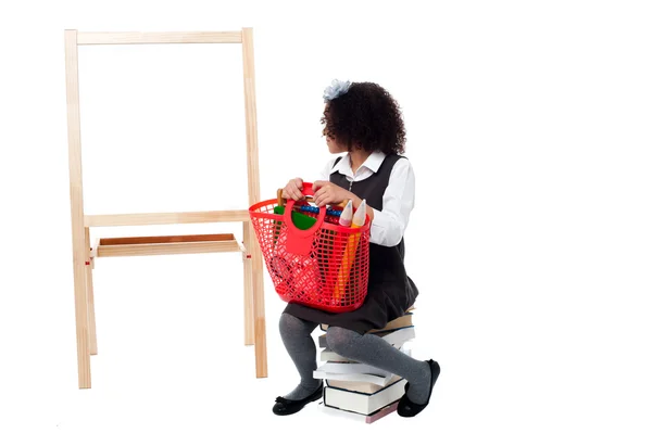 Escola menina sentada em livros — Fotografia de Stock