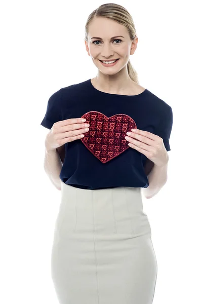 Femme montrant boîte cadeau en forme de coeur — Photo