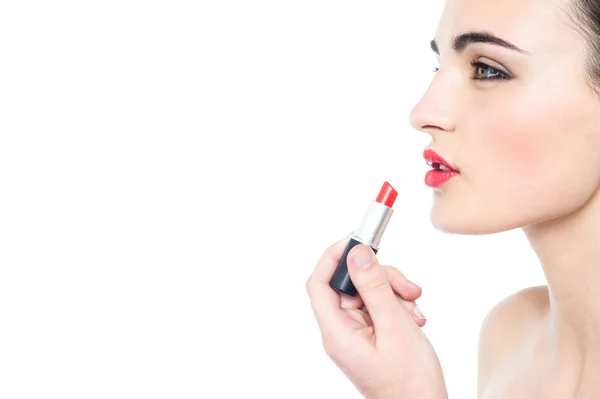 Modelo adolescente aplicando lápiz labial rojo —  Fotos de Stock