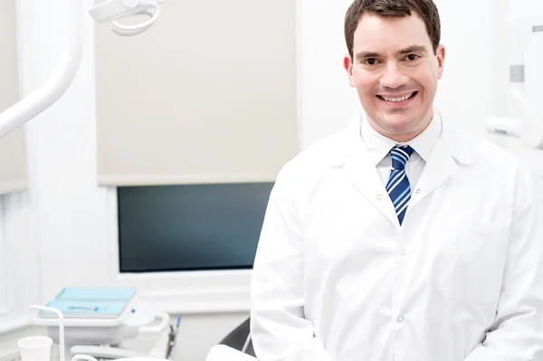 Dentista masculino posando na clínica odontológica — Fotografia de Stock