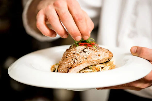 Chef hand garnishing tuna appetizer — Stock Photo, Image