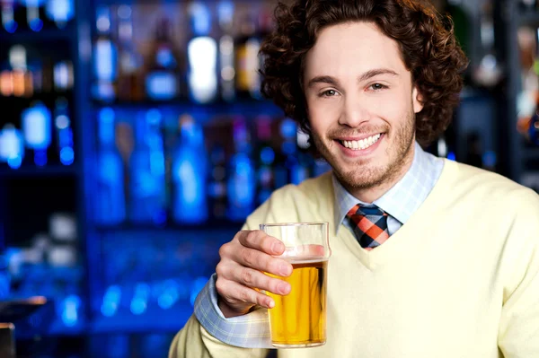 man at bar holding glass of beer