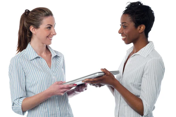 Woman giving laptop to her friend — Stock Photo, Image