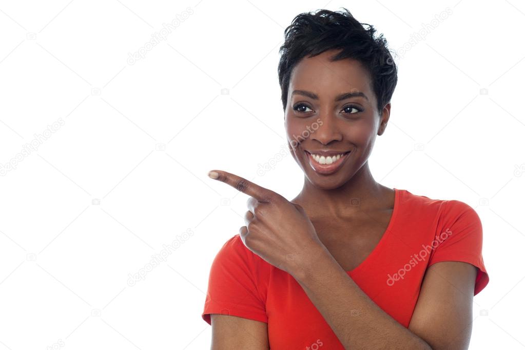 Young smiling woman pointing away