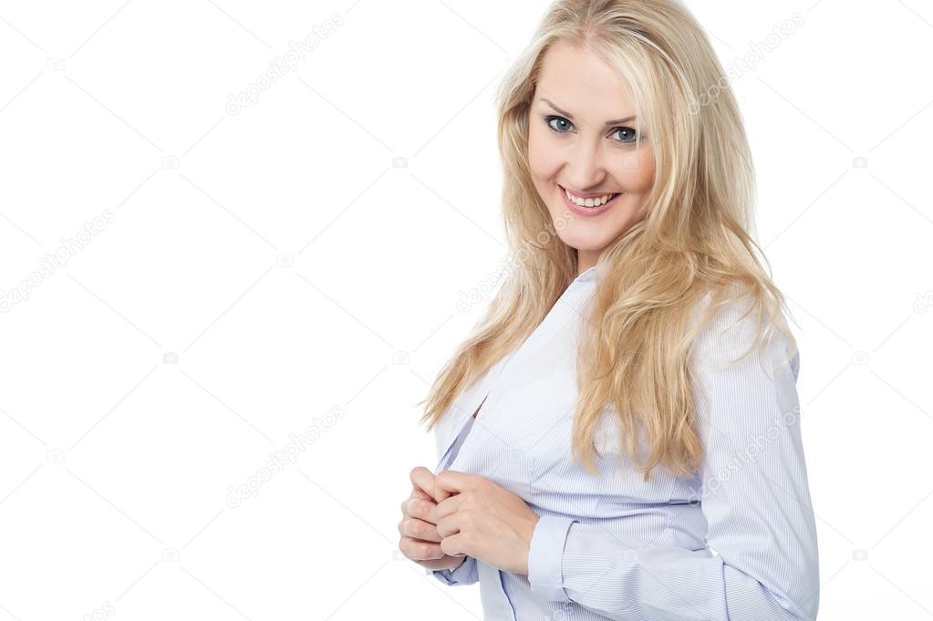 Flirtatious woman unbuttoning her shirt on white background.