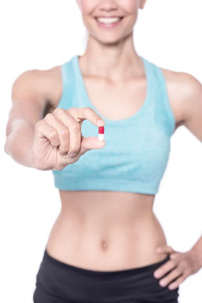 Jeune femme en forme montrant la médecine — Photo