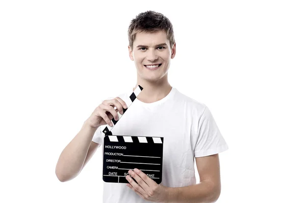 Young guy posing with a clapperboard — Stock Photo, Image