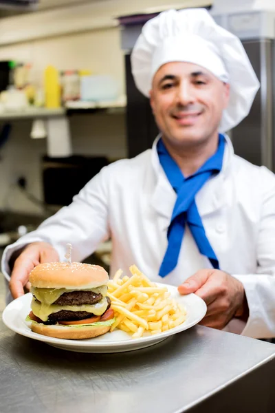 Szef kuchni, prezentując Hamburger i frytki — Zdjęcie stockowe