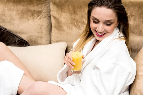 Mujer en albornoz bebiendo jugo de naranja —  Fotos de Stock