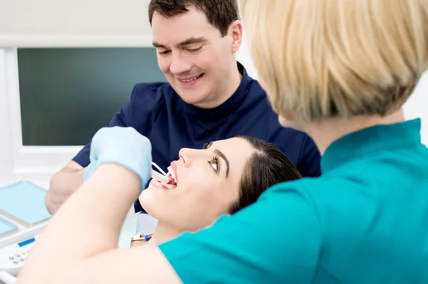 Жінка-стоматолог на роботі з чоловічим помічником — стокове фото