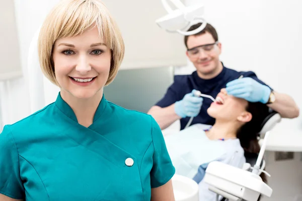 Diş hekimi ve hasta kadın Yardımcısı arkasında — Stok fotoğraf