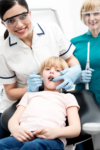 Dentista operando dientes de niña niña — Foto de Stock