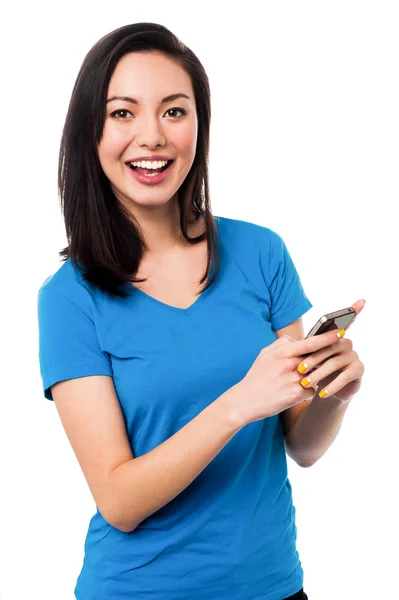 Casual young woman using smartphone — Stock Photo, Image