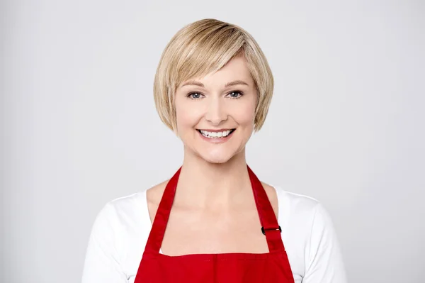 Vrouw chef-kok in rode schort — Stockfoto