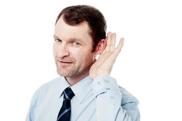 Corporate executive hearing with hand on ear — Stock Photo, Image