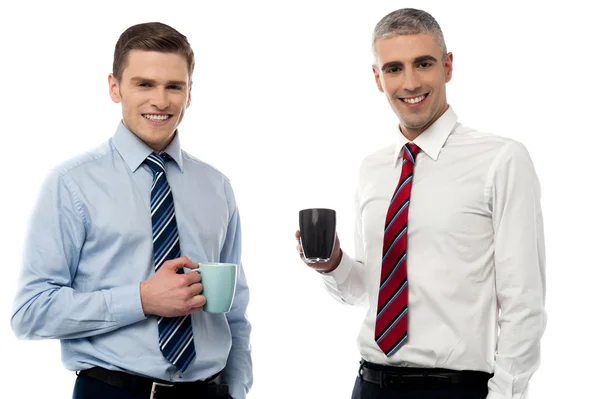 Guapos hombres de negocios sosteniendo tazas de café — Foto de Stock