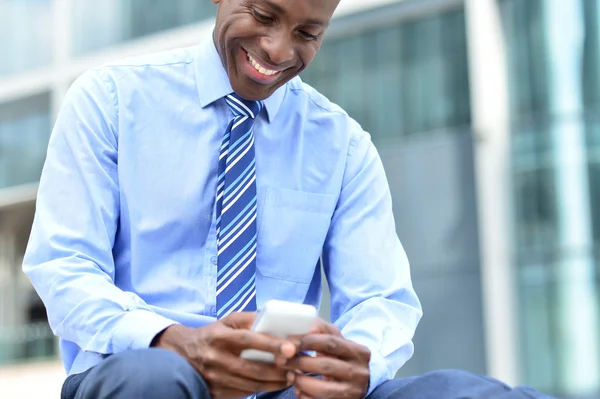 Empresário masculino olhando para seu celular — Fotografia de Stock
