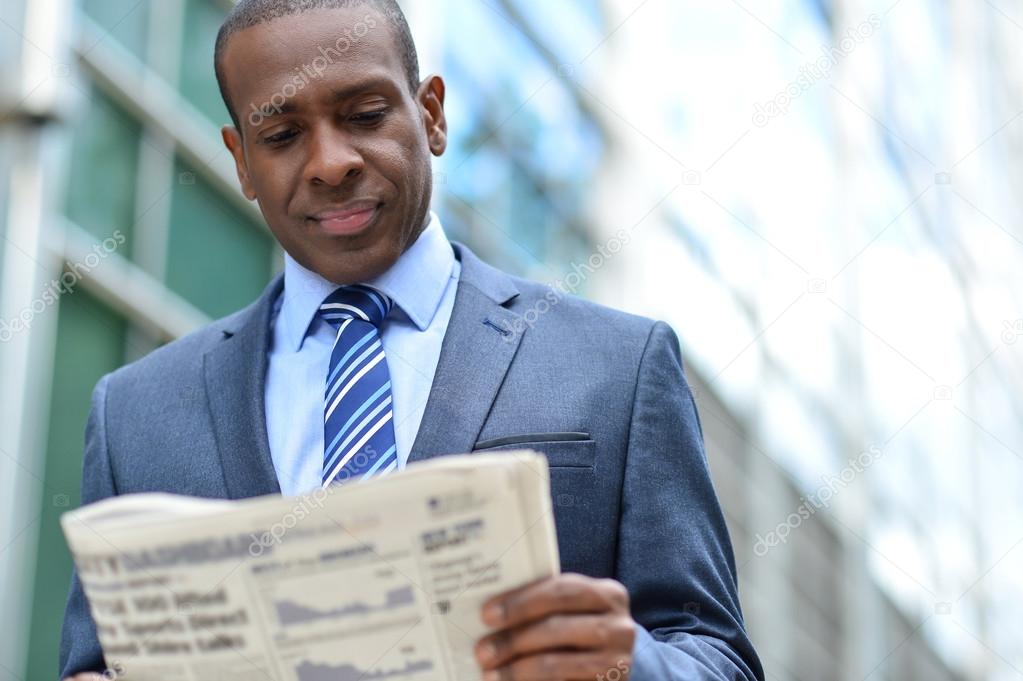 businessman reading newspaper seriously