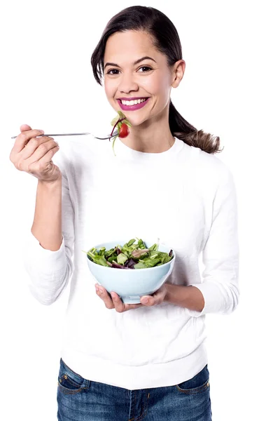 Jovem mulher comendo salada verde — Fotografia de Stock