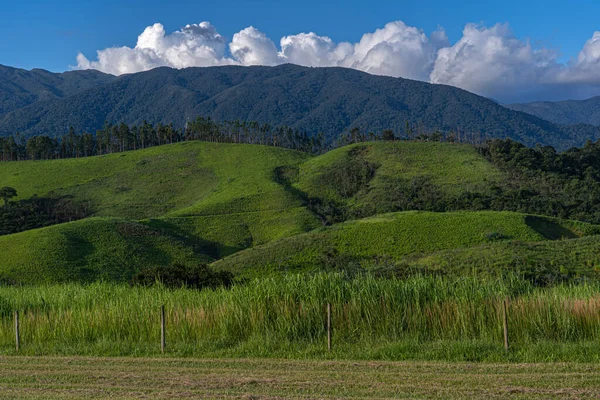 青空と雲の背景を持つ緑の丘の山のフィールドの美しい景色 — ストック写真