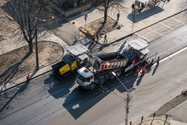 KYIV, UKRAINE - 10 Eylül 2020: Sokaktaki yol şantiyesine taze asfalt döşeyen endüstriyel asfalt kaldırım makineleri.