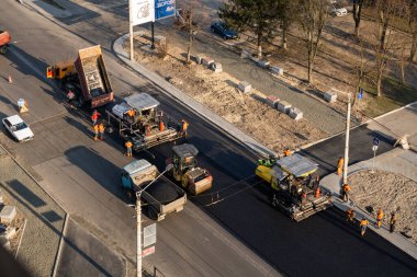 KYIV, UKRAINE - 10 Eylül 2020: Ağır asfalt yol silindirli ağır titreşimli paten sıkıştırıcısı yeni asfalt ve asfalt kaldırıcı makinesini bir sokak inşaatında çalıştırıyor.
