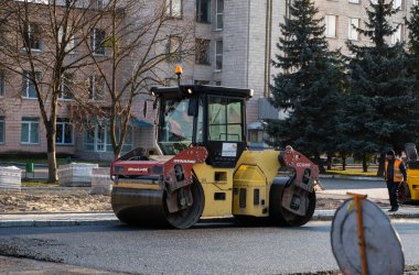 KYIV, UKRAINE - 10 Eylül 2020: Ağır asfalt yol silindirli ağır titreşimli paten sıkıştırıcısı, bir cadde üzerindeki yol inşaatında yeni bir sıcak asfalta baskı yapıyor..