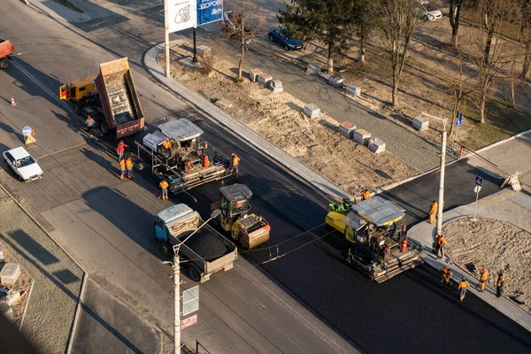 KYIV, UKRAINE - 10 września 2020: Ciężki asfaltowy wałek drogowy z ciężkim zagęszczaczem wibracyjnym, który wciska nowy gorący asfalt i nawierzchnię asfaltową na budowie drogi na ulicy. — Zdjęcie stockowe