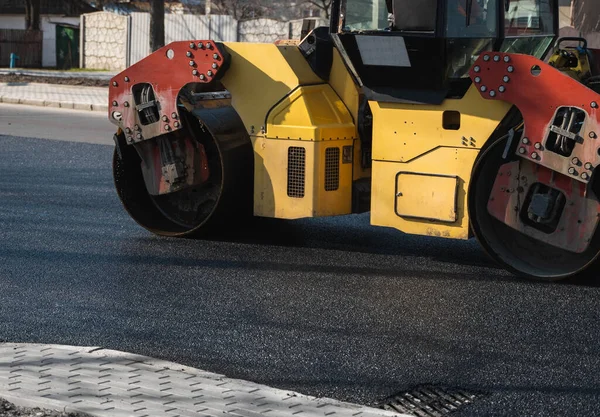 Asfalt road roller z ciężkimi wibracjami rolki zagęszczarki naciśnij nowy gorący asfalt na jezdni na placu budowy dróg. Ciężki wałek wibracyjny na asfaltowej nawierzchni działa. Naprawa. — Zdjęcie stockowe