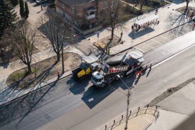 KYIV, UKRAINE - 10 Eylül 2020: Sokaktaki yol şantiyesine taze asfalt döşeyen endüstriyel asfalt kaldırım makineleri.