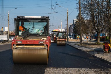 KYIV, UKRAINE - 10 Eylül 2020: Ağır asfalt yol silindirli ağır titreşimli paten sıkıştırıcısı, bir cadde üzerindeki yol inşaatında yeni bir sıcak asfalta baskı yapıyor..