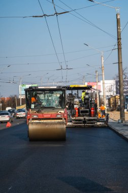 KYIV, UKRAINE - 10 Eylül 2020: Ağır asfalt yol silindirli ağır titreşimli paten sıkıştırıcısı, bir cadde üzerindeki yol inşaatında yeni bir sıcak asfalta baskı yapıyor..
