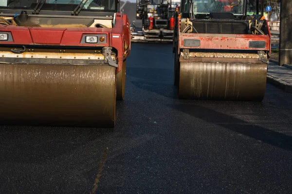 Asfalt road roller z ciężkimi wibracjami rolki zagęszczarki naciśnij nowy gorący asfalt na jezdni na placu budowy dróg. Ciężki wałek wibracyjny na asfaltowej nawierzchni działa. Naprawa. — Zdjęcie stockowe