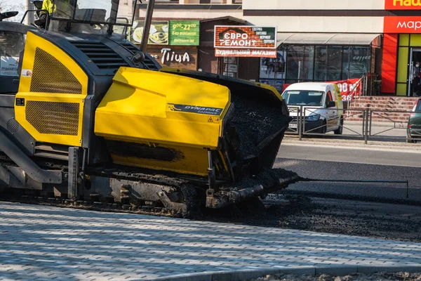 KYIV, UKRAINE - 10 września 2020: Przemysłowa nawierzchnia asfaltowa układająca świeży asfalt na budowie dróg na ulicy. — Zdjęcie stockowe